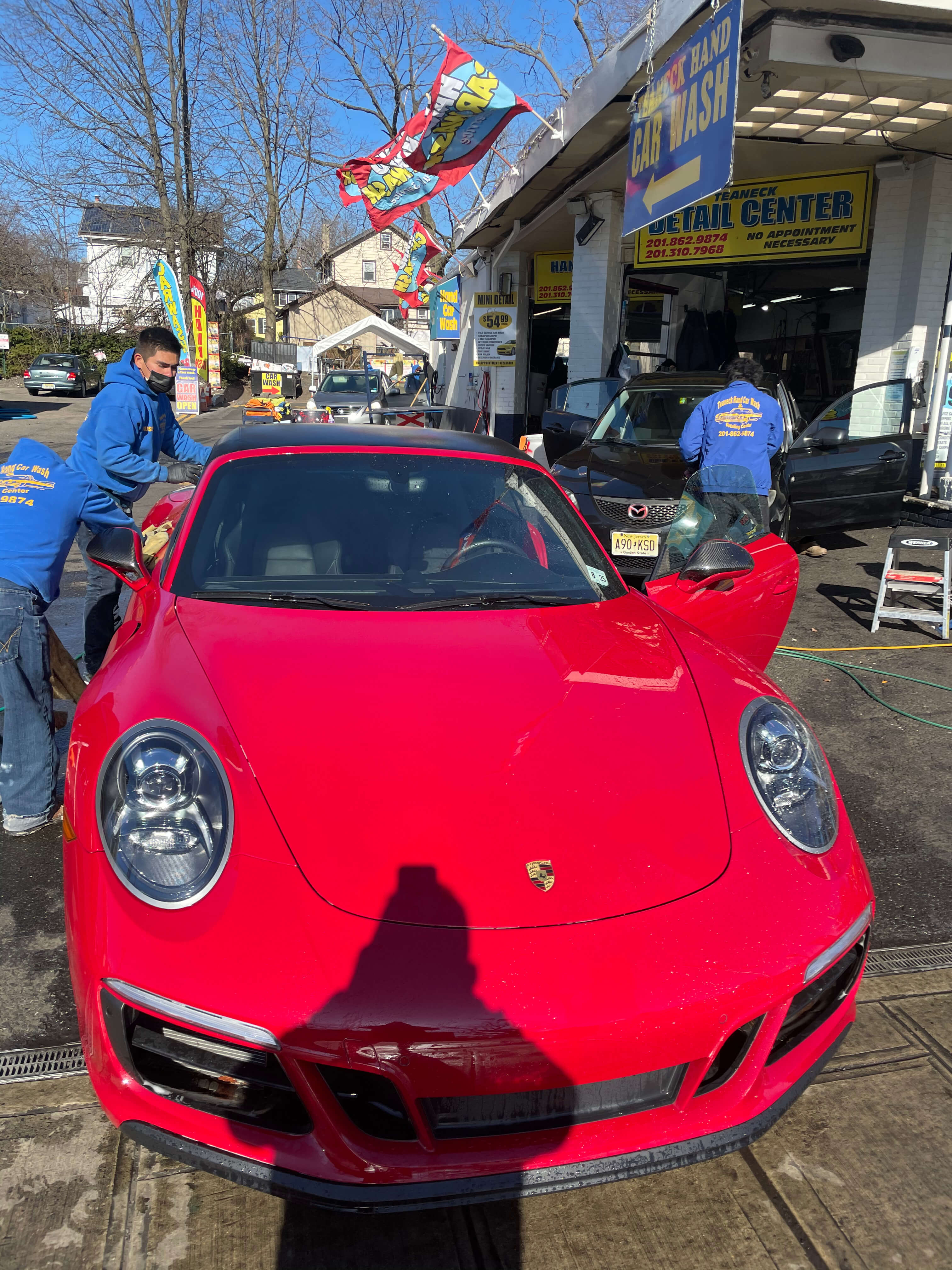 Red Porsche 911 receiving professional care at Teaneck Hand Car Wash