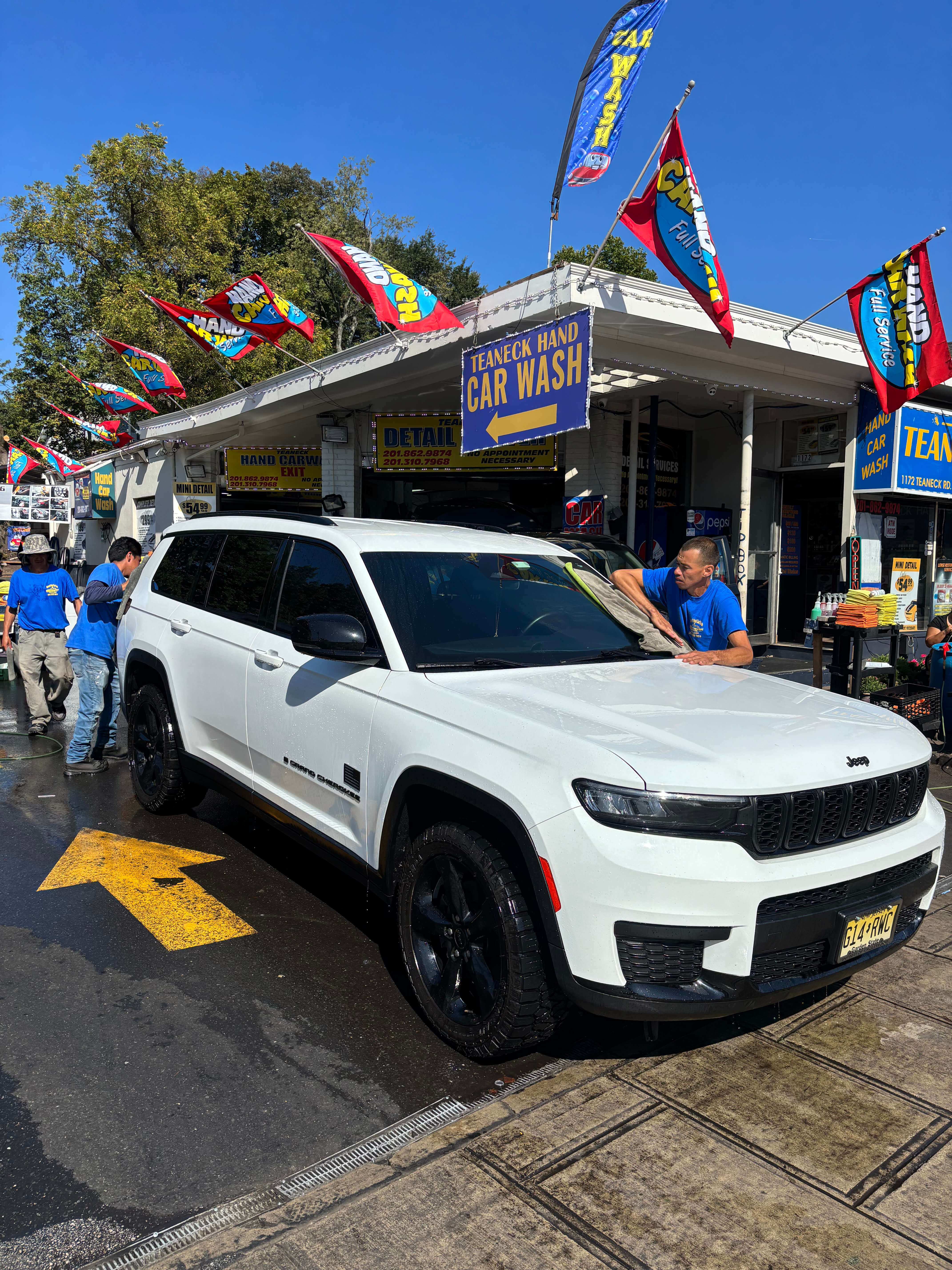 White Jeep Grand Cherokee being hand washed at Teaneck Hand Car Wash